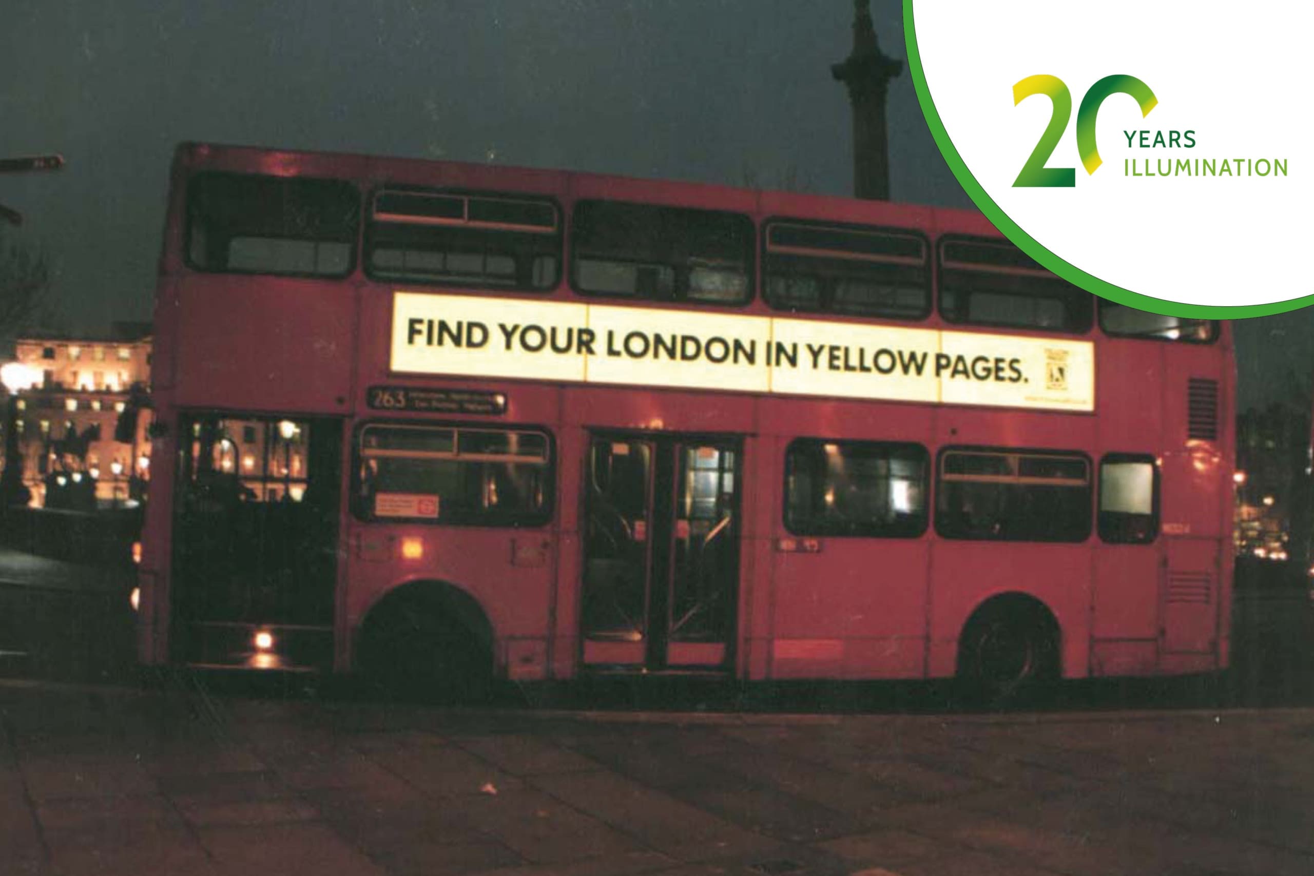 A classic red double-decker bus in London at night features an illuminated advertisement on the side that reads, "Find your London in Yellow Pages." Celebrating "20 Years of Illumination".